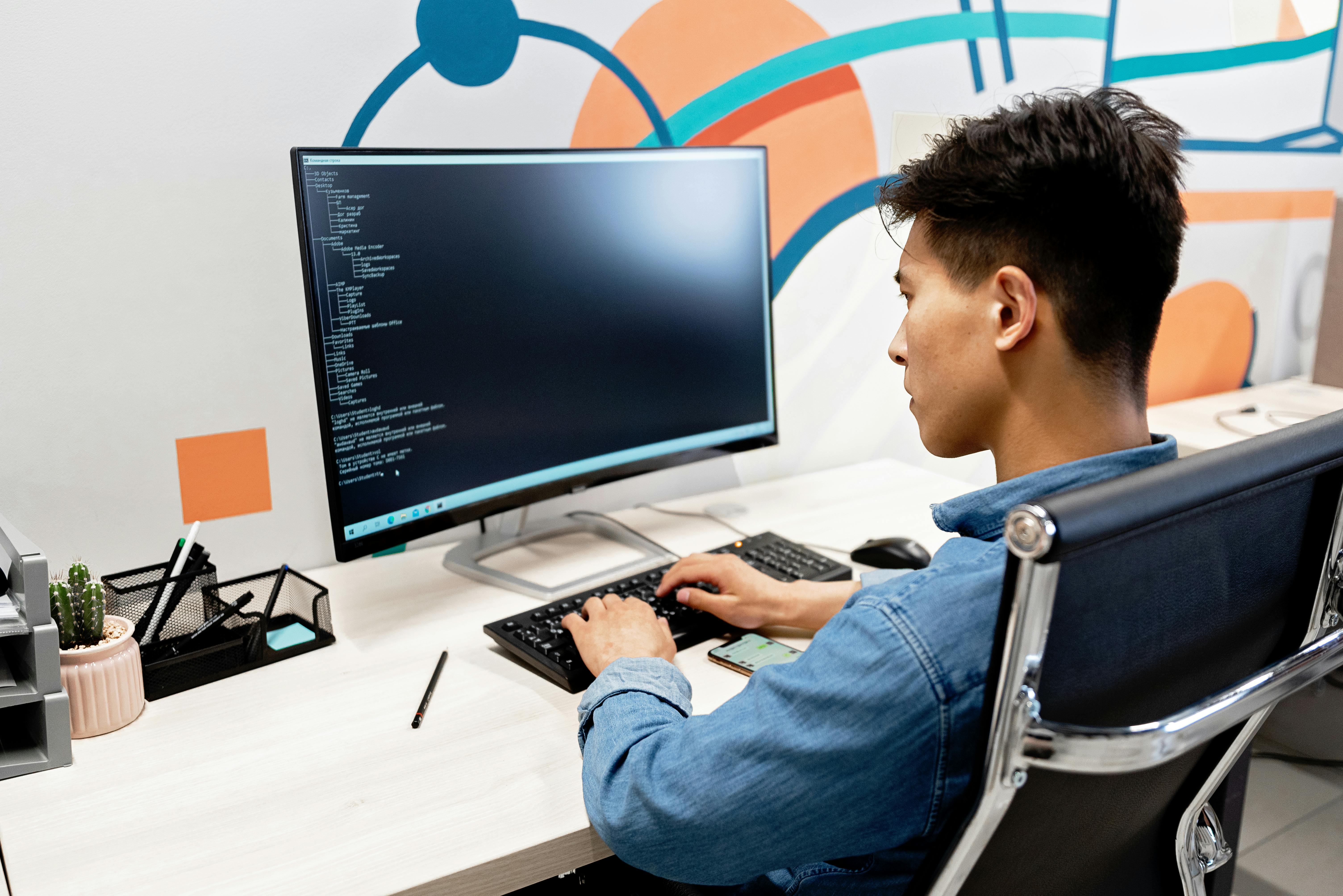 IT professional working at a desk with monitor and keyboard