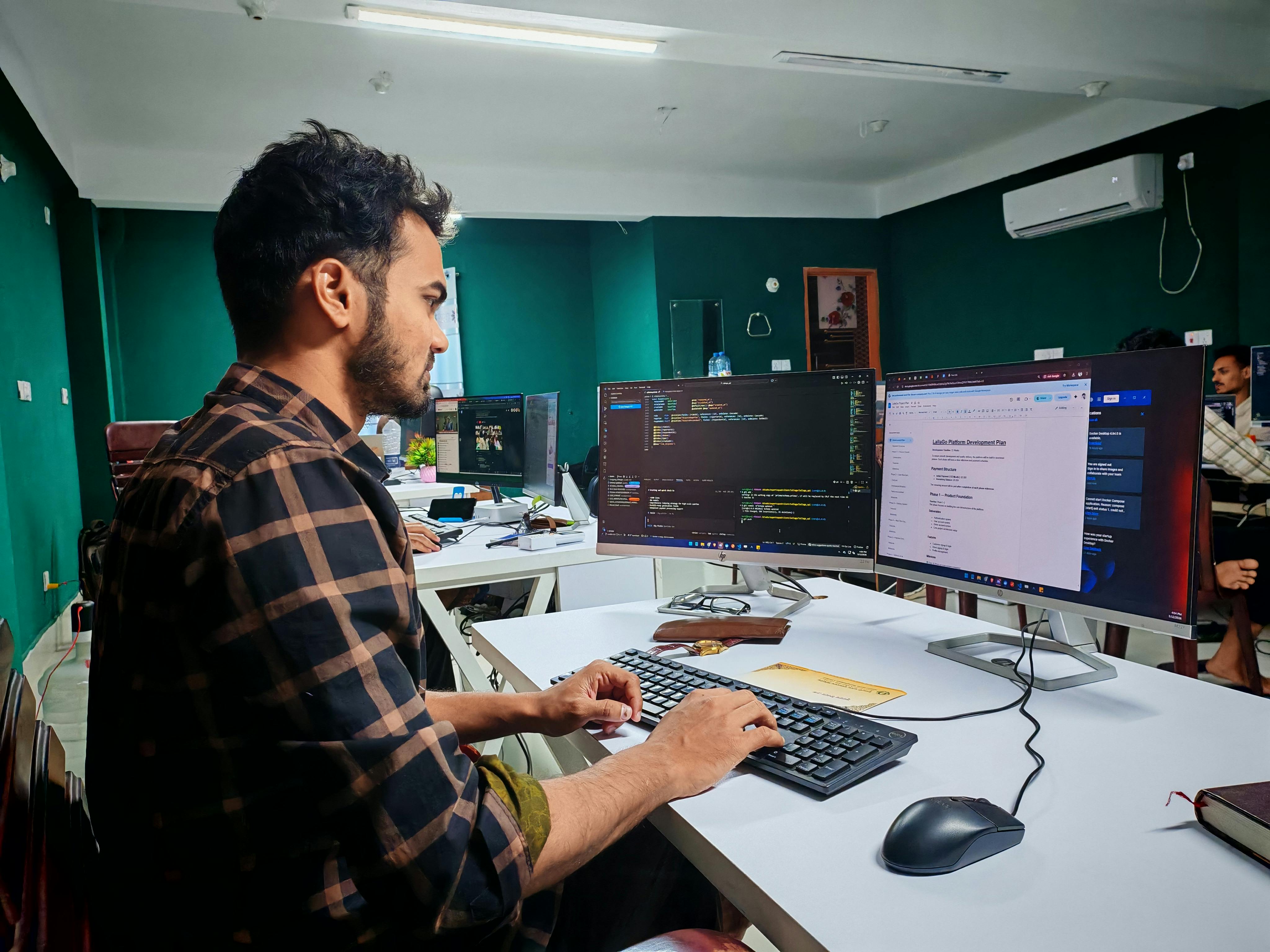 IT technician working on dual monitors in an office