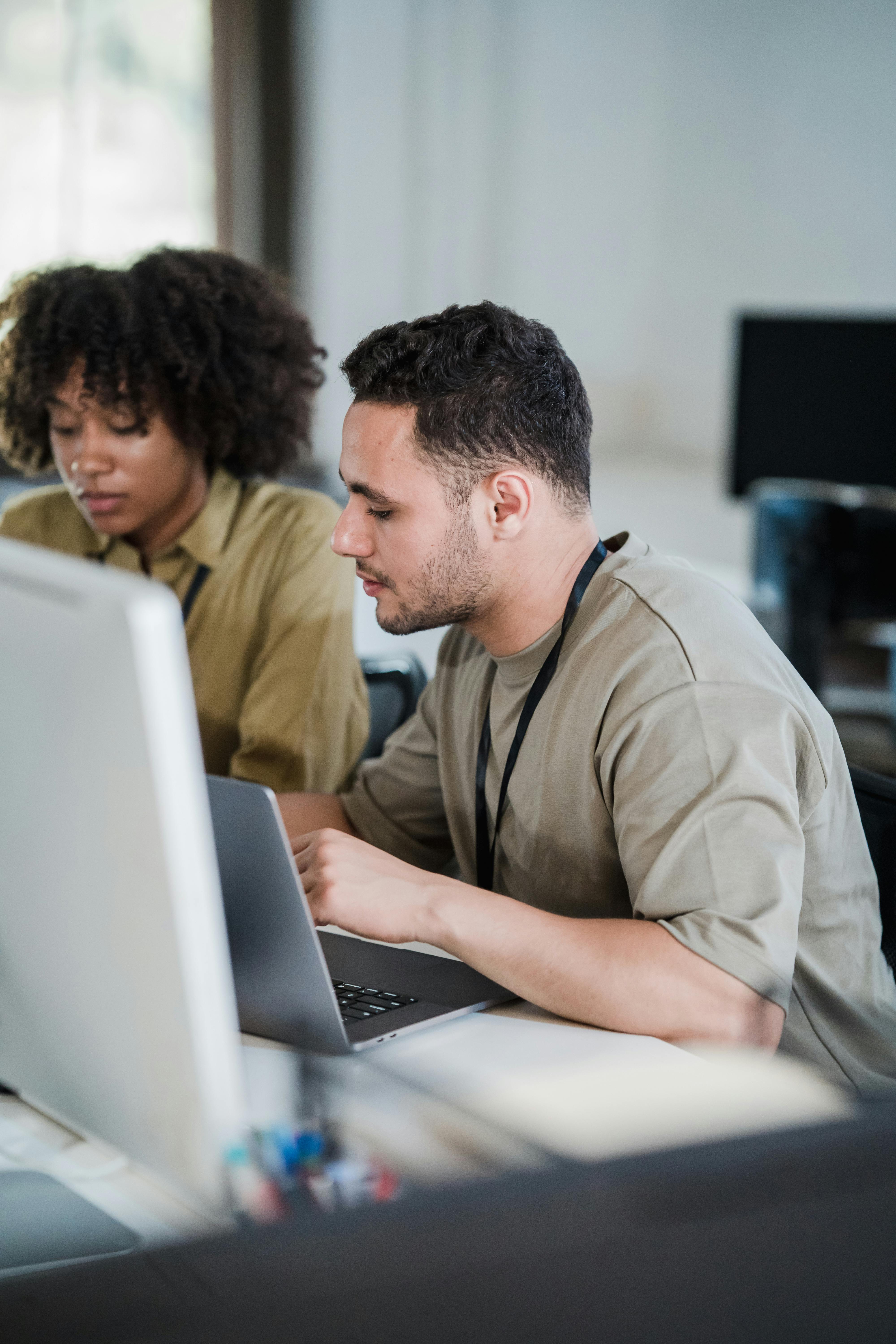 IT staff collaborating on a laptop in an office environment