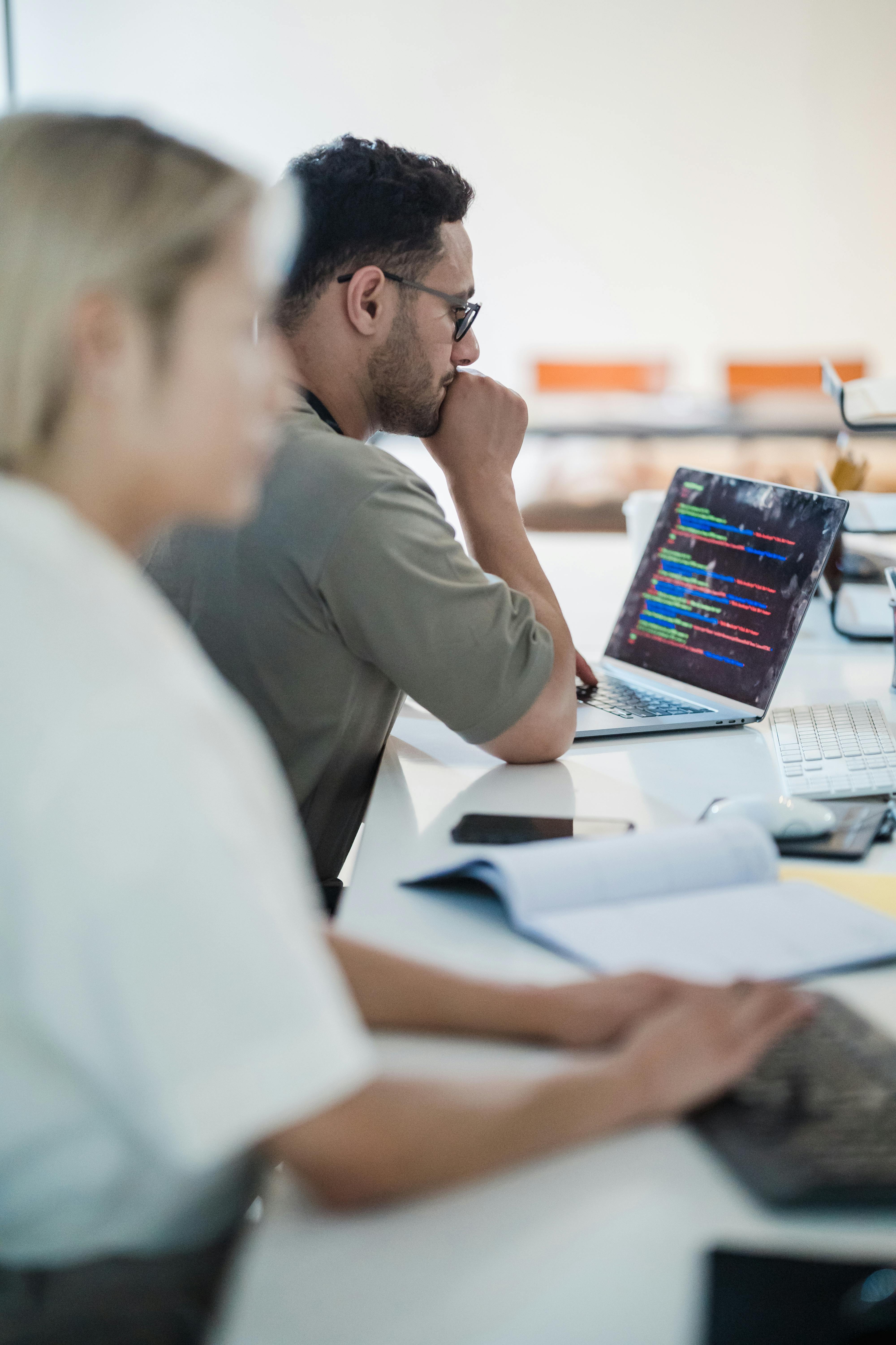 IT team members working together on laptops in an office